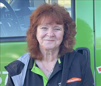 Office Receptionist & Job Dispatcher, Anne, standing in front of one of our SERVPRO vehicles.
