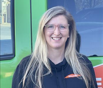 Our Accounting & HR Administrator, Holly, standing in front of one of our SERVPRO vehicles.