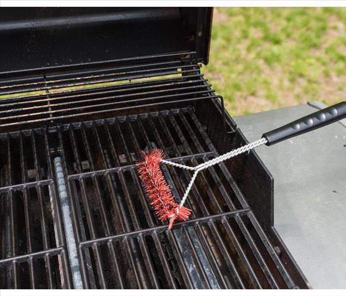 Angled view of scrubbing utensil used for cleaning a dirty grill. BBQ Grill Background Theme